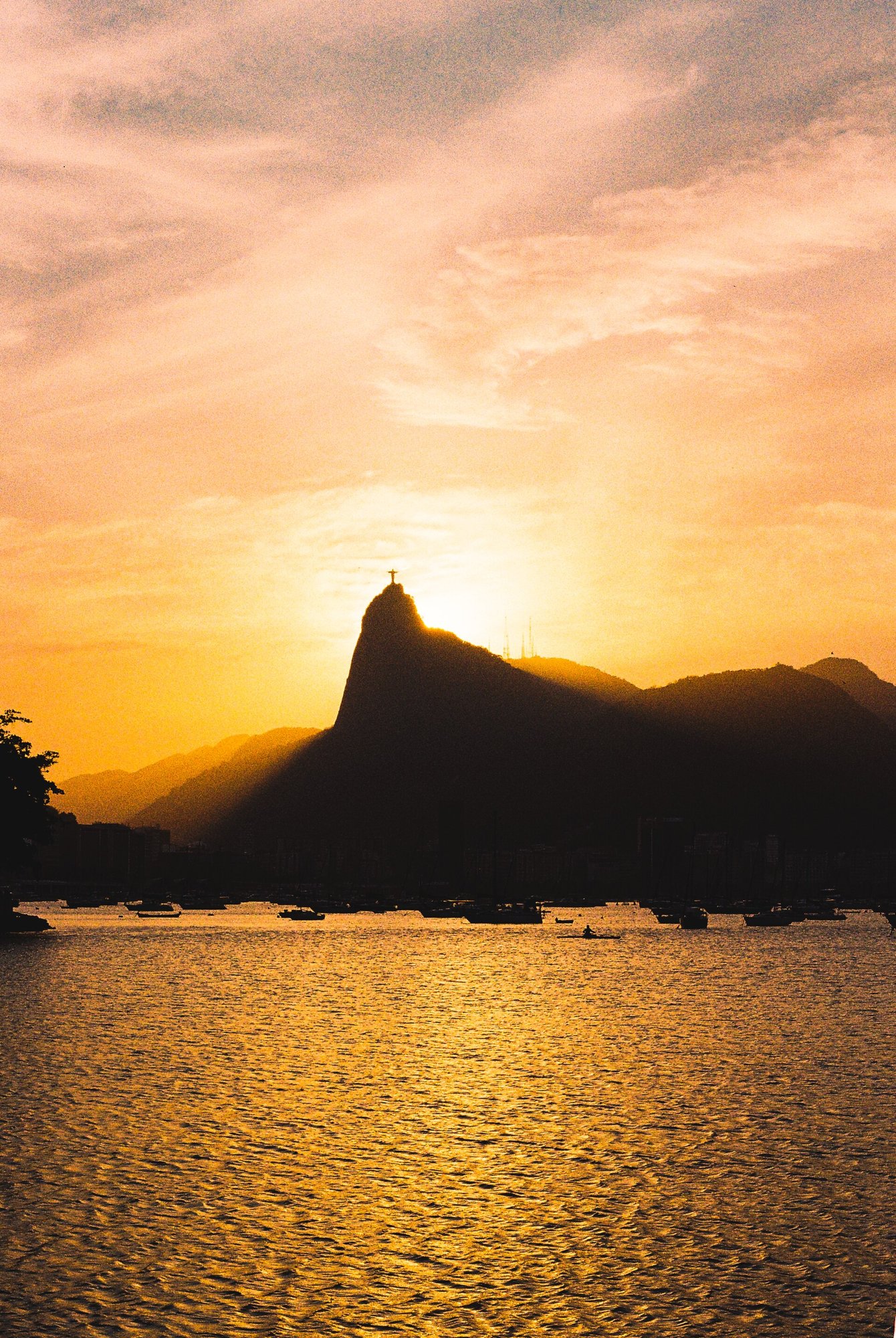 Pôr do sol sobre a Baía de Guanabara visto da Urca, com o Cristo Redentor no horizonte